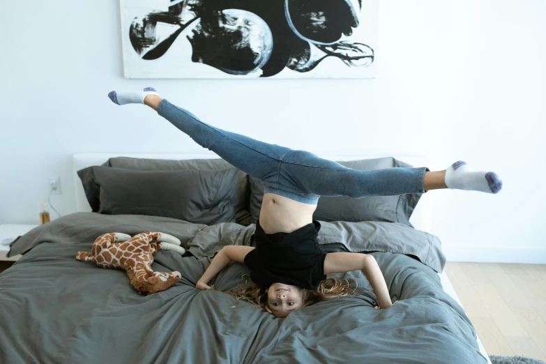 a woman laying on top of a bed next to a giraffe, inspired by Elizabeth Polunin, pexels contest winner, arabesque, doing a backflip, sydney hanson, bedhead, spread wings