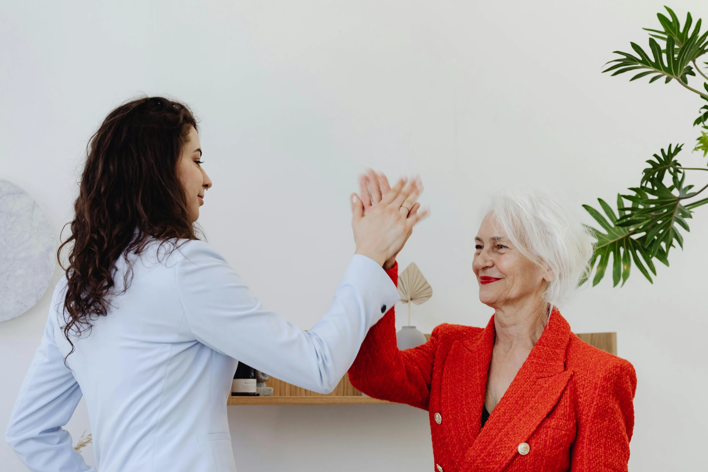 a woman giving a high five to an older woman, by Emma Andijewska, low quality photo, slightly minimal, profile image