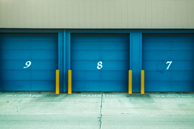 a row of blue garage doors with numbers painted on them, a minimalist painting, unsplash, postminimalism, square, 8l, yellow, three