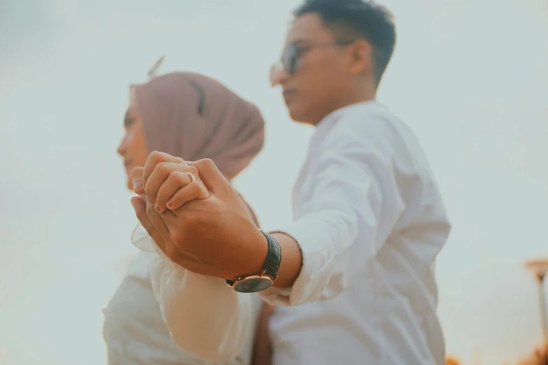 a man and a woman are holding hands, pexels contest winner, islamic, casual pose, smooth in _ the background, no watermark