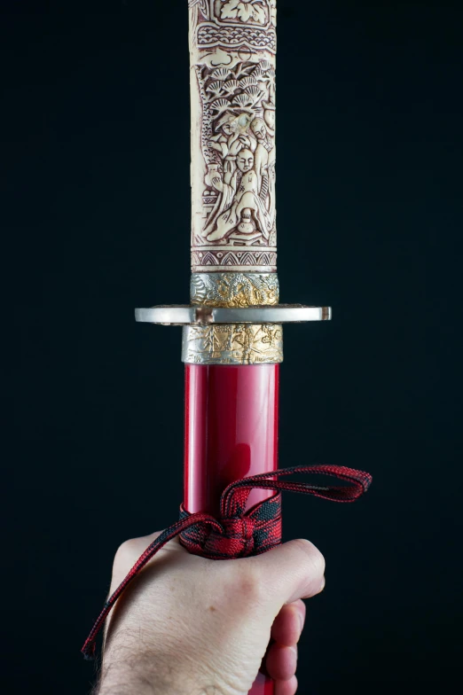 a close up of a person holding a knife, inspired by Kanō Hōgai, gold and red filigree, slide show, tall, product shot