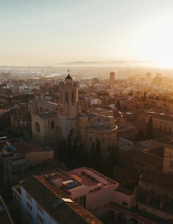 an aerial view of a city at sunset, inspired by Modest Urgell, pexels contest winner, romanesque, cathedral in the background, wide image, looking towards camera, cinematic lut