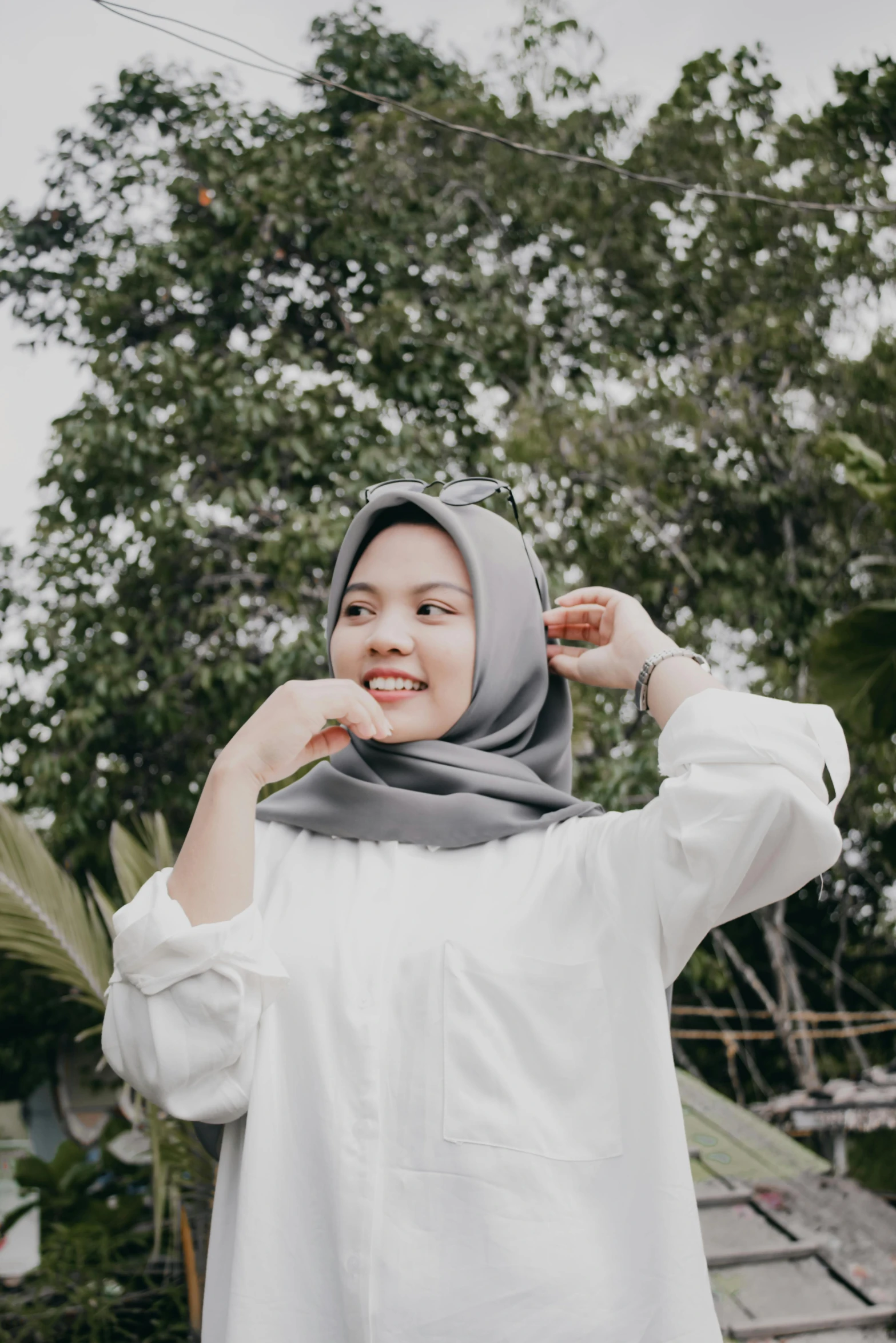 a woman wearing a hijab standing in front of a tree, inspired by Naza, pexels contest winner, white and grey, handsome girl, casual, white and silver
