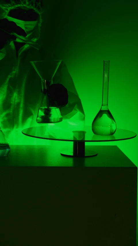 a couple of glass vases sitting on top of a table, a hologram, by Doug Ohlson, experiment in laboratory, green light, product photo, vantablack gi