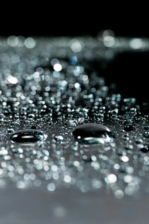 a close up of water droplets on a surface, 2 0 % pearlescent detailing, intricate sparkling atmosphere, gradient black to silver