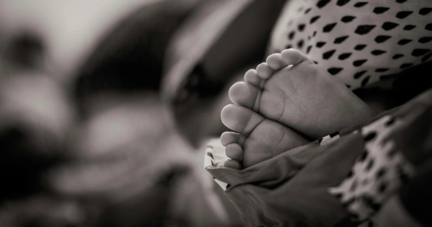 a black and white photo of a baby's feet, by Adam Marczyński, pexels contest winner, fan favorite, teenage girl, sepia, fatherly