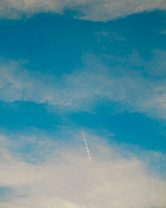 a plane flying through a cloudy blue sky, an album cover, pexels contest winner, postminimalism, ☁🌪🌙👩🏾, air particles, sherbert sky, the photo was taken from afar