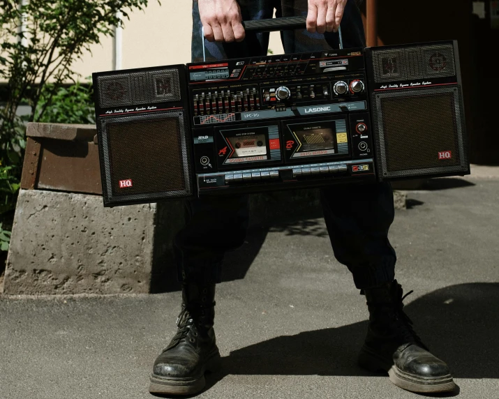 a man holding a boombox in his hands, pexels contest winner, giant speakers, old cmputers on the sidewalk, in style of nan goldin, mix between tribal and hi-tech