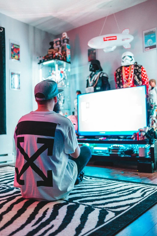 a man sitting on the floor in front of a television, maximalism, outlive streetwear collection, x - box, bad bunny, love death + robots