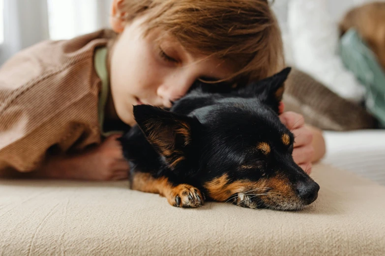 a little boy that is laying down with a dog, pexels contest winner, hugging and cradling, profile image, thumbnail, australian