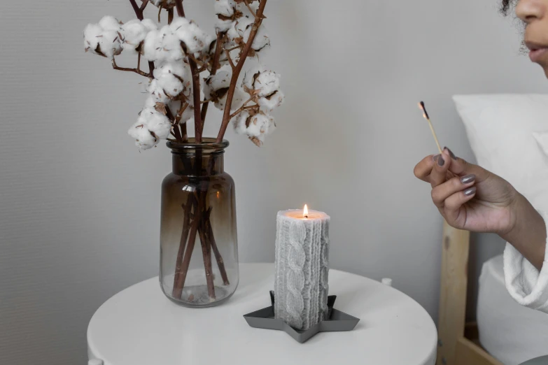 a woman sitting next to a table holding a cell phone, a marble sculpture, inspired by Joseph Beuys, instagram, romanticism, on a candle holder, light grey, high textured, cosy enchanted scene