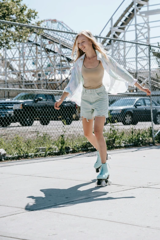 a woman riding a skateboard down a sidewalk, a colorized photo, inspired by Elsa Bleda, trending on unsplash, pale blue outfit, wearing a camisole and boots, at a skate park, model posing