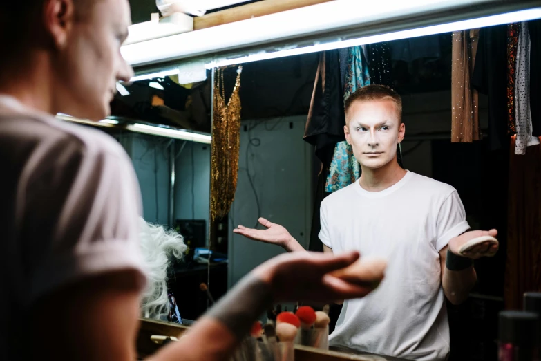 a man that is standing in front of a mirror, a portrait, unsplash, prosthetic makeup, a pale skin, theater dressing room, limmy