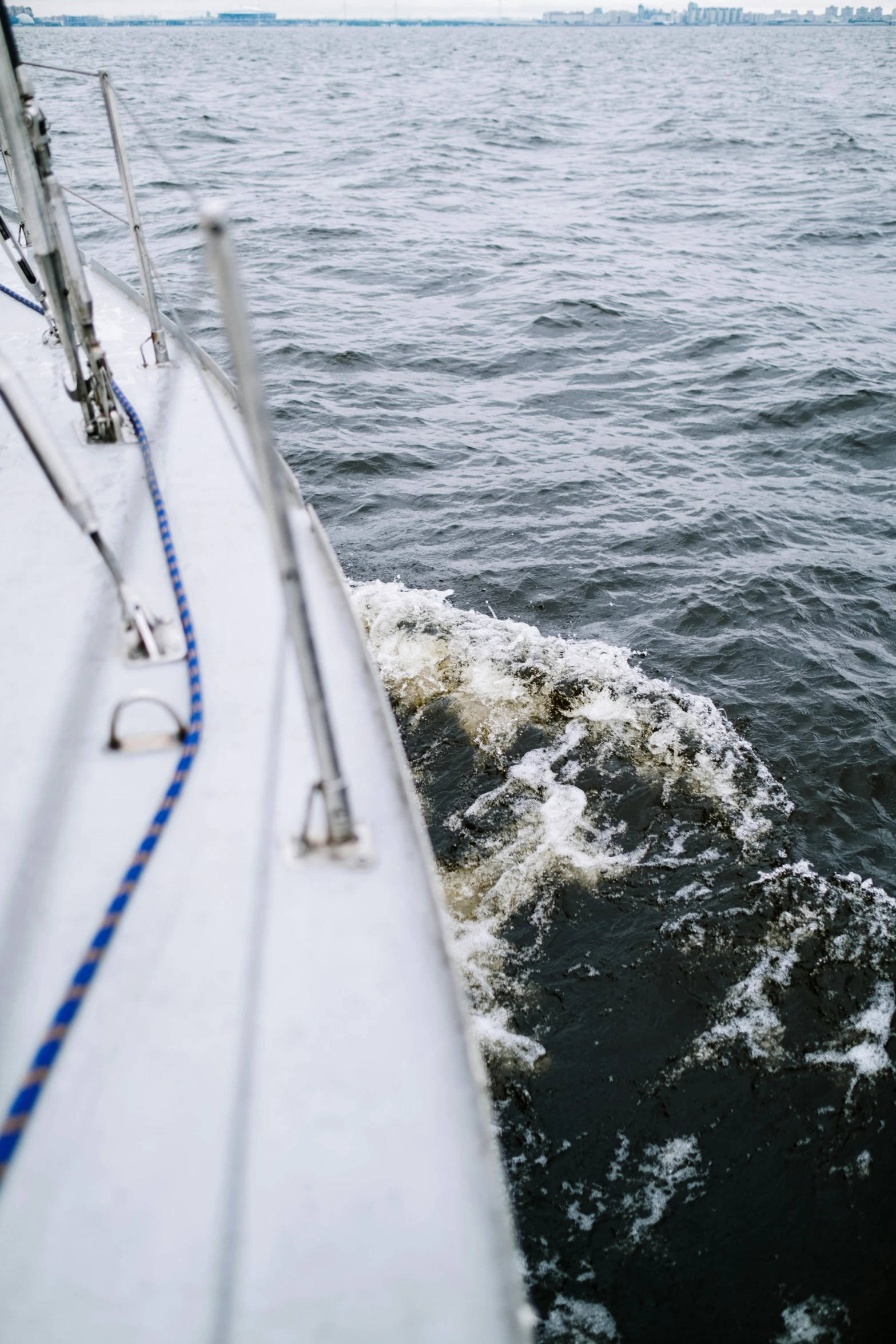 a boat traveling across a body of water, happening, up close, set sail, bending down slightly, a high angle shot