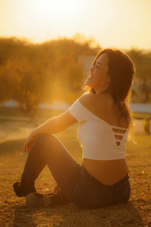 a woman sitting on top of a grass covered field, sport bra and shirt, sunny lighting, extremely happy, 2019 trending photo