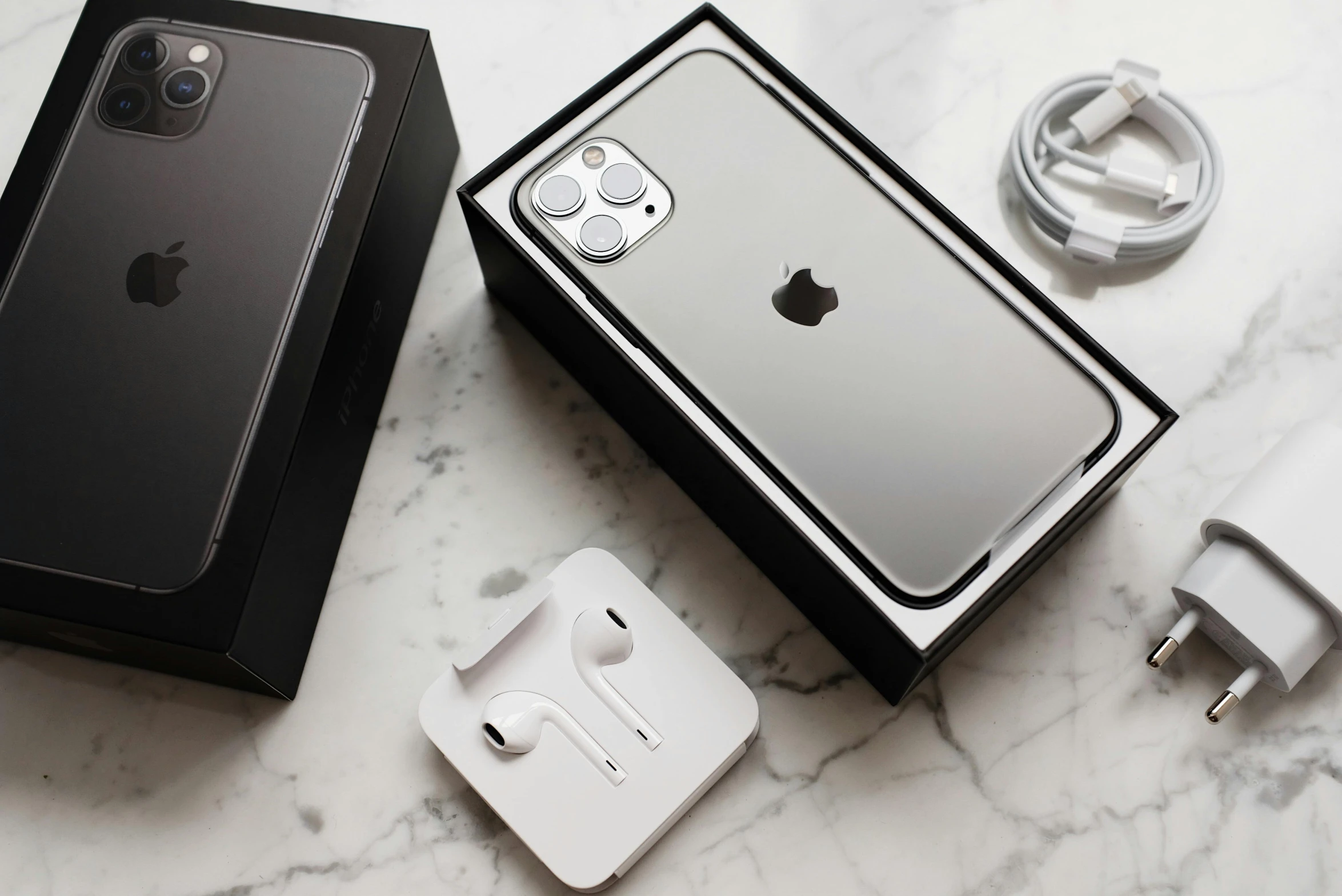 an iphone sitting on top of a table next to a charger, listing image, grey and silver, packaging, black and white color aesthetic