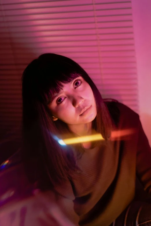 a woman holding a nintendo wii game controller, an album cover, inspired by Miwa Komatsu, unsplash, altermodern, police lights shine on her face, with a fringe, portrait sophie mudd, japan. volumetric lighting