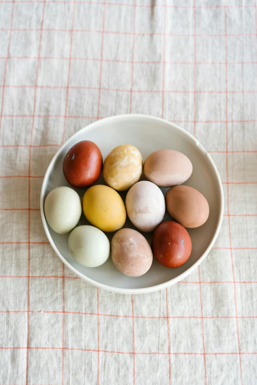 a bowl filled with eggs sitting on top of a table, various colors, matte finish, oregon, cross-hatchings