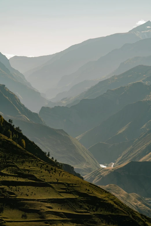 a view of a valley with mountains in the background, by Muggur, unsplash contest winner, les nabis, inca, light haze, slate, high quality photo