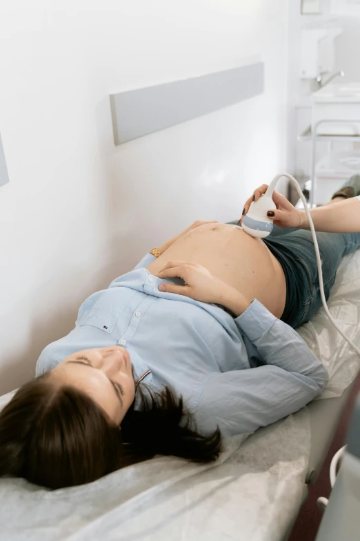 a pregnant woman laying on a hospital bed, a colorized photo, ultra precise, thumbnail, lightweight, us