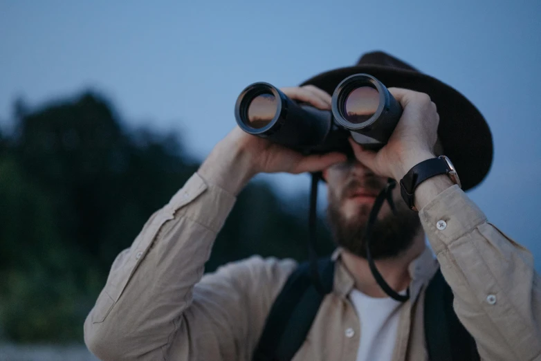 a man looking through a pair of binoculars, trending on pexels, calm night. over shoulder shot, inspect in inventory image, thumbnail, bird sight