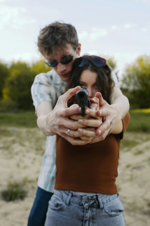 a man standing next to a woman holding a gun, a picture, flickr, ap news photograph, gen z, romantic lead, mid air shot