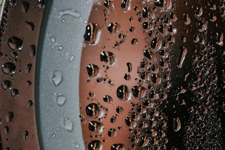 a close up of water droplets on a window, an album cover, photorealism, dripping bbq sauce, dark matte metal, gradient brown to silver, bottom - view