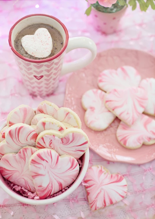 a pink table topped with cookies and a cup of coffee, candy canes, swirly magic ripples, magic heart, fan favorite