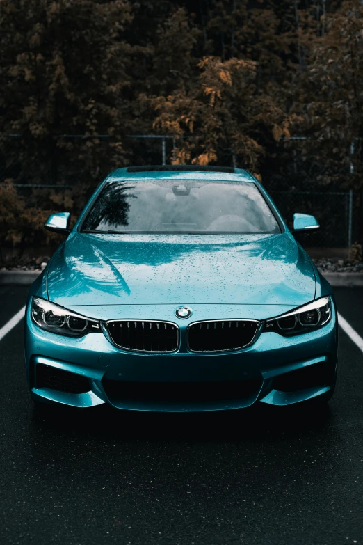 a blue bmw car parked in a parking lot, by Adam Marczyński, pexels contest winner, dynamic pearlescent teal light, front of car angle, frontal picture, cover shot