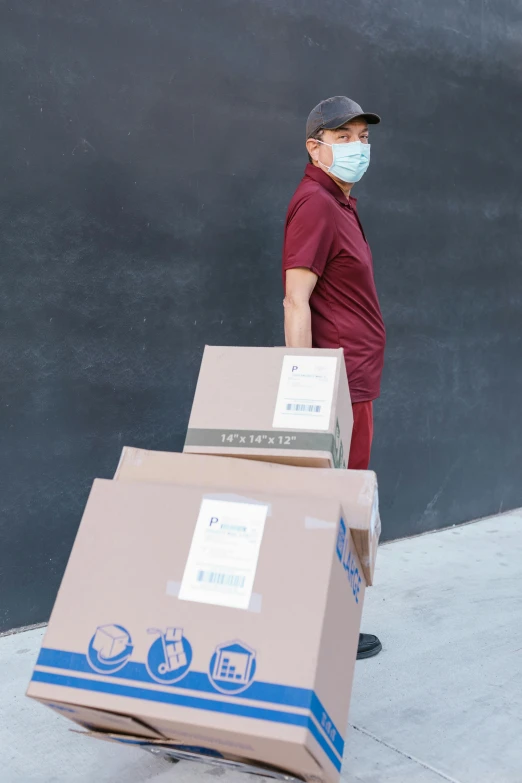 a man wearing a face mask and carrying boxes, maroon, large and tall, los angeles, (doctor)