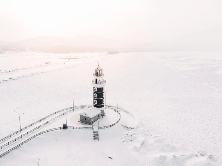 a lighthouse sitting on top of a snow covered beach, drone photograpghy, white pale concrete city, unsplash photography, near lake baikal