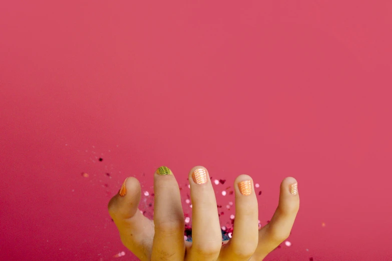 a woman's hand holding a donut with sprinkles on it, by Julia Pishtar, trending on pexels, pop art, nail polish, gradient pink, 3 colours, show from below