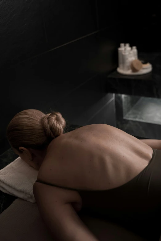 a woman getting a back massage at a spa, by Sam Black, renaissance, pitch black room, face down, grey, rectangle