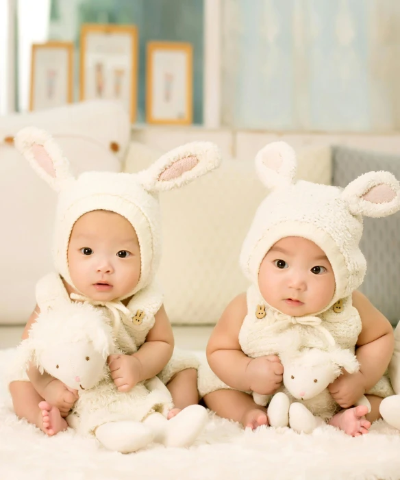 a couple of babies sitting on top of a white rug, pexels contest winner, wearing a bunny suit, ethnicity : japanese, adult pair of twins, square