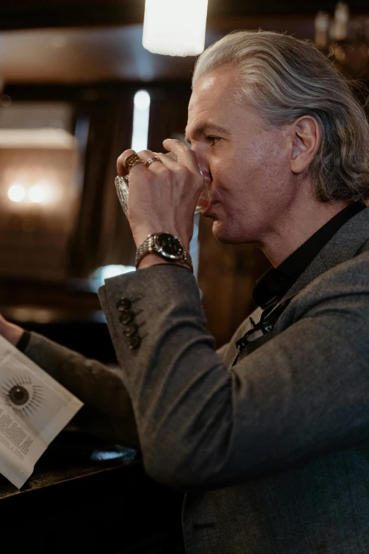 a man sitting at a bar drinking a glass of wine, a portrait, trending on unsplash, baroque, david spade, holding grimoire, henrik fisker, smelling good