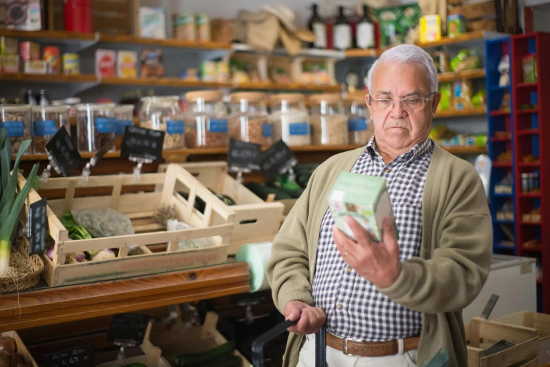 a man standing in a store looking at a cell phone, dementia, new zeeland, portrait image, local foods