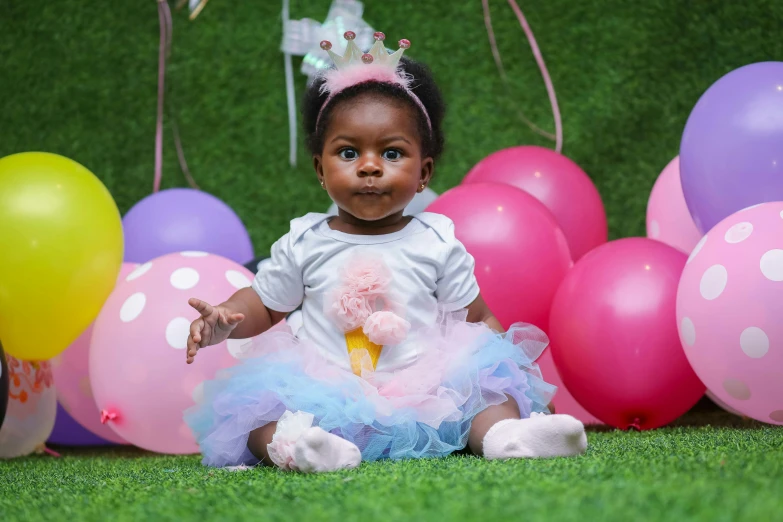 a baby girl sitting in front of a bunch of balloons, by Chinwe Chukwuogo-Roy, pexels contest winner, birthday cake on the ground, summer princess, a handsome, gardening