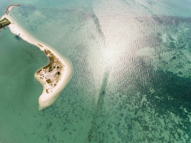 an island in the middle of a body of water, by Julian Allen, pexels contest winner, hurufiyya, dredged seabed, soft-sanded coastlines, jill stingray, birdseye view