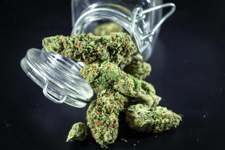 a jar of marijuana sitting on top of a table, by Arnie Swekel, pexels, hurufiyya, flower buds, dynamic closeup, sprawling, thumbnail