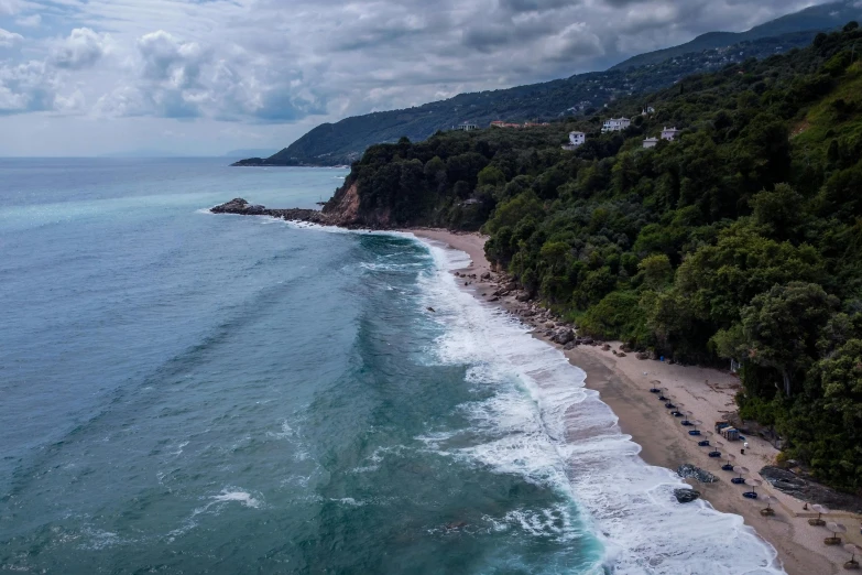 a large body of water next to a lush green hillside, a photo, pexels contest winner, renaissance, mediterranean beach background, stormy coast, drone footage, breakfast