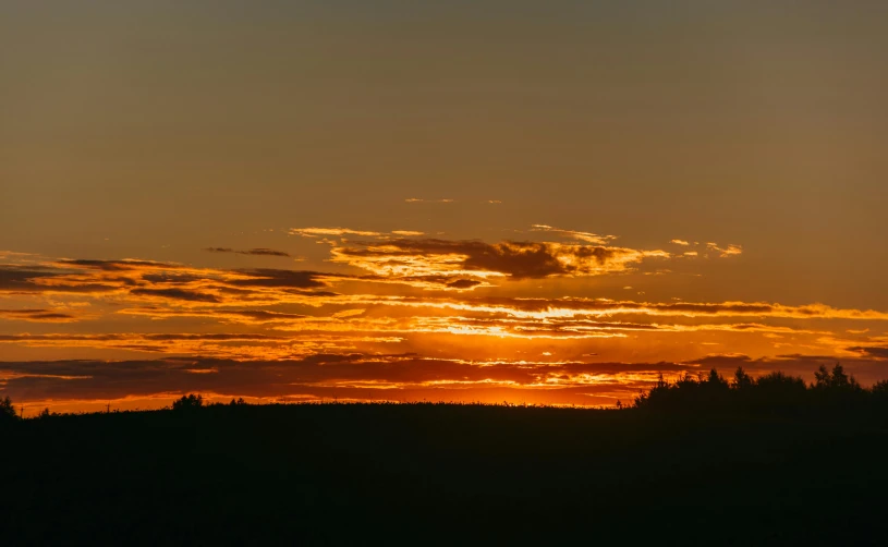 a person is flying a kite at sunset, by Jesper Knudsen, pexels contest winner, romanticism, distant forest horizon, orange clouds, panorama, northern finland