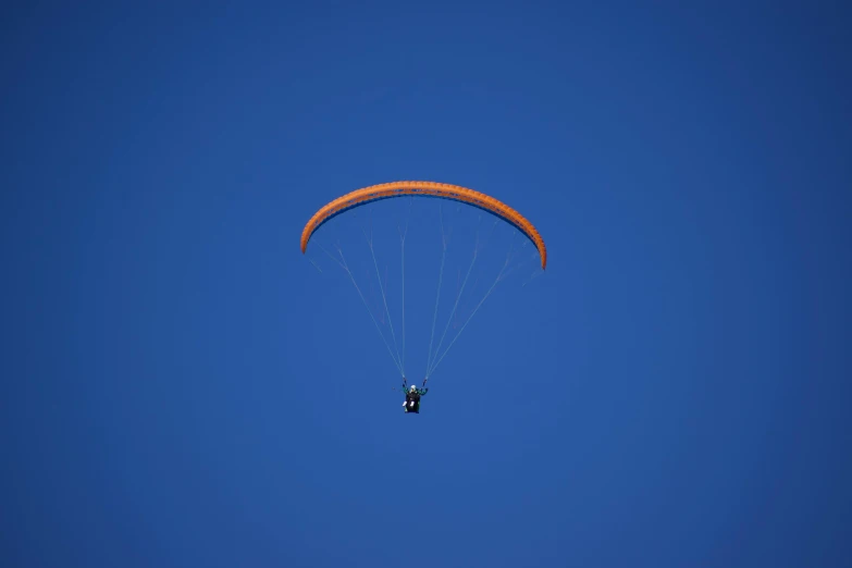 a person paragliding in the blue sky, by Niko Henrichon, pexels contest winner, hurufiyya, rectangle, picton blue, blue orange