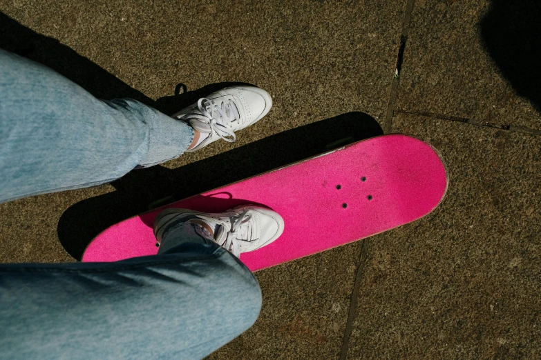 a person standing on top of a pink skateboard, pexels contest winner, wearing white sneakers, birdseye view, full colour, slides