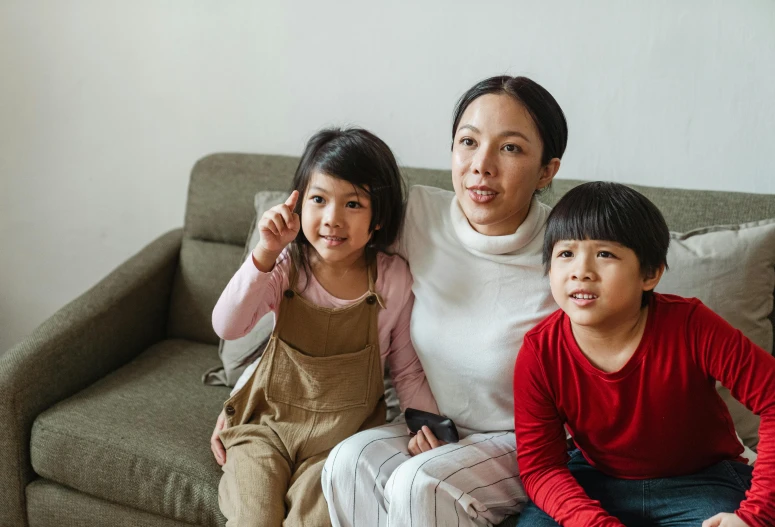 a woman and two children sitting on a couch, pexels contest winner, asian descent, everything fits on the screen, future activist, she is korean