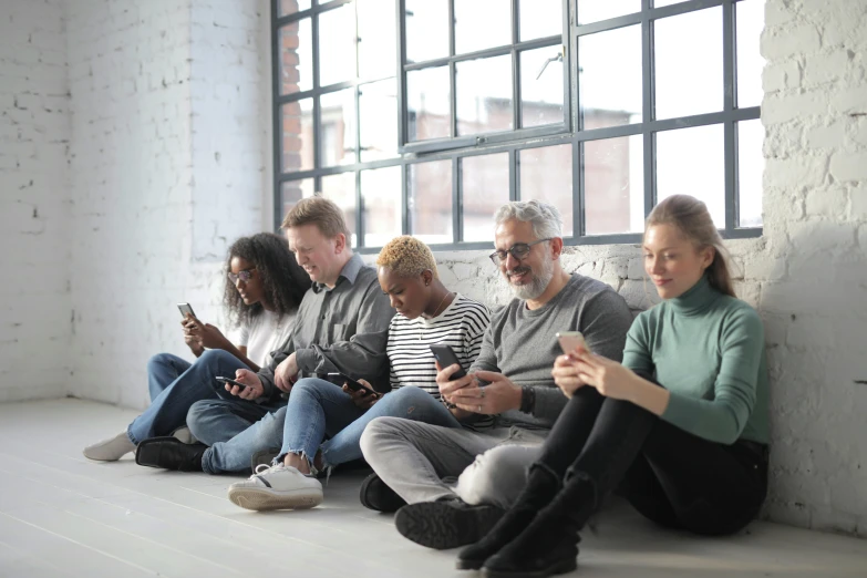 a group of people sitting next to each other on their cell phones, grey, thumbnail, 1 petapixel image