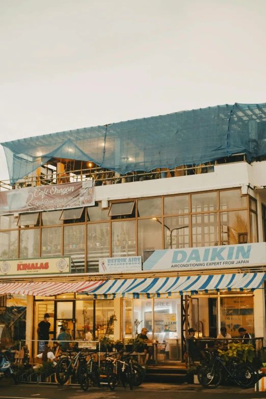 a group of motorcycles parked in front of a building, cafe in the clouds, golden hour in boracay, silk tarps hanging, tehran