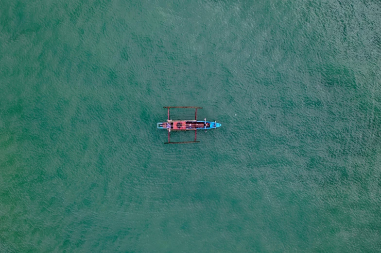 a small boat in the middle of a large body of water, pexels contest winner, red green black teal, bali, full frame image, blue