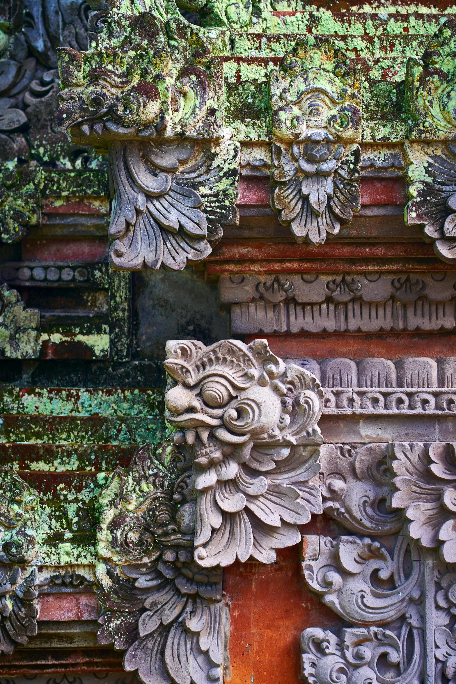 a close up of a building with carvings on it, lush surroundings, indonesia, mossy buildings, swirling