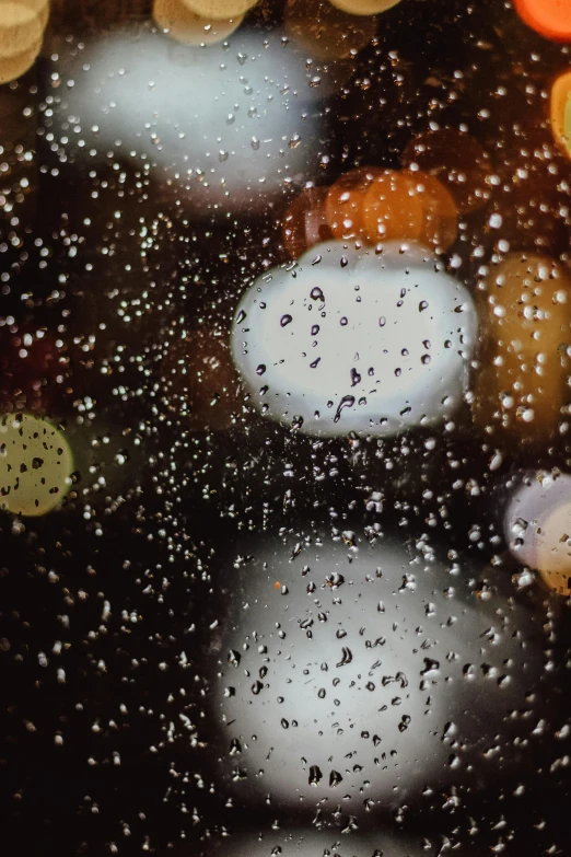 a close up of a window with raindrops on it, inspired by Elsa Bleda, trending on unsplash, street lights water refraction, holiday season, wet reflections in square eyes, swirly bokeh