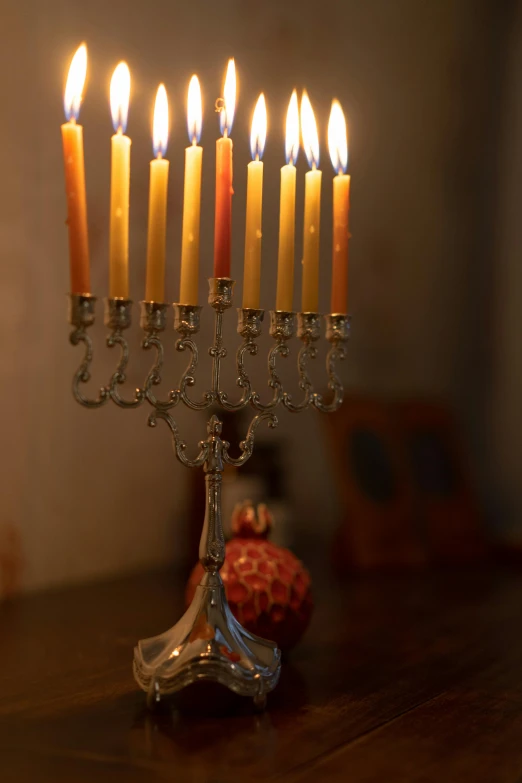 a group of lit candles sitting on top of a wooden table, jerusalem, silver ornaments, shot on sony a 7, square